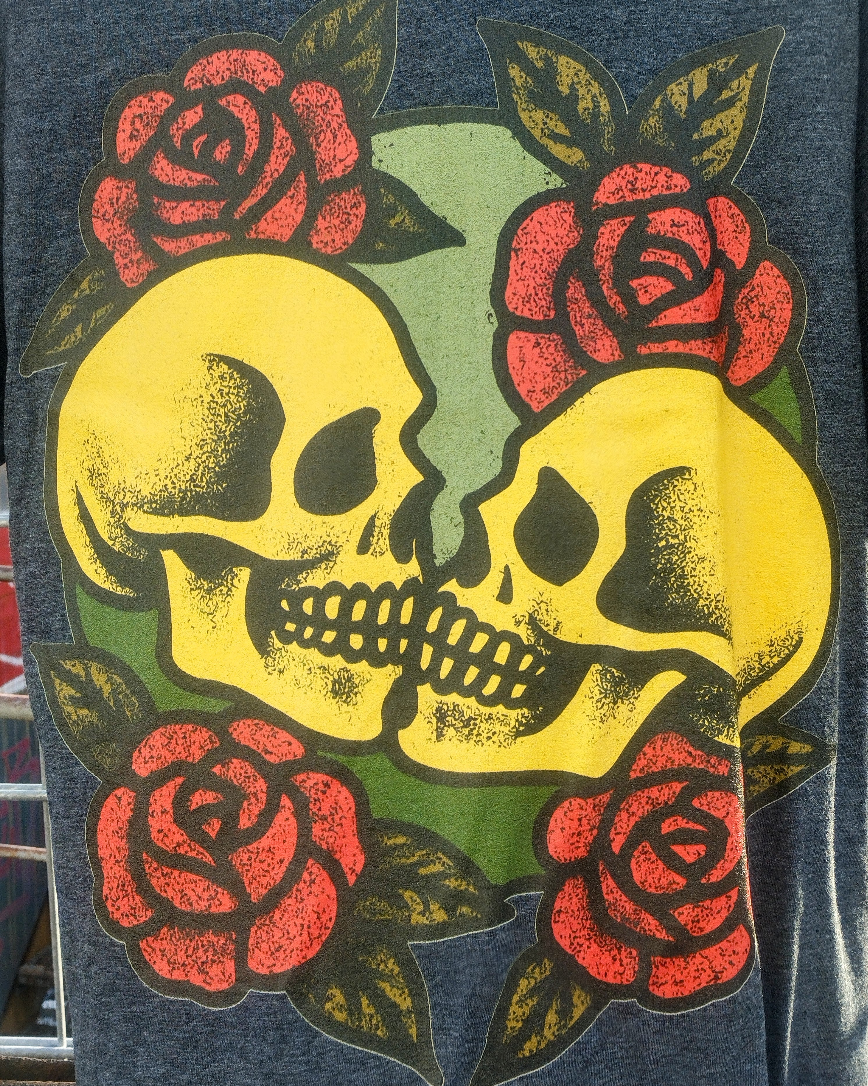 Two yellow skulls with red roses on a dark background