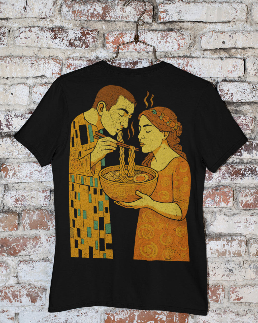 Black t-shirt with a graphic design of a man and woman eating noodles against a brick wall background