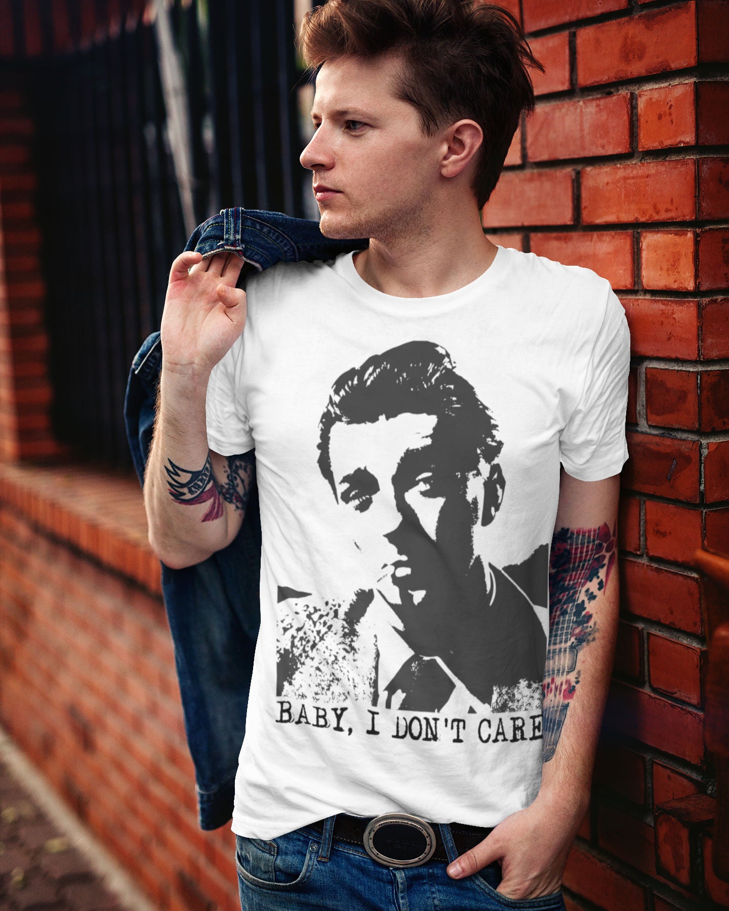 Man wearing a white t-shirt with an image of Robert Mitchum, standing against a brick wall.