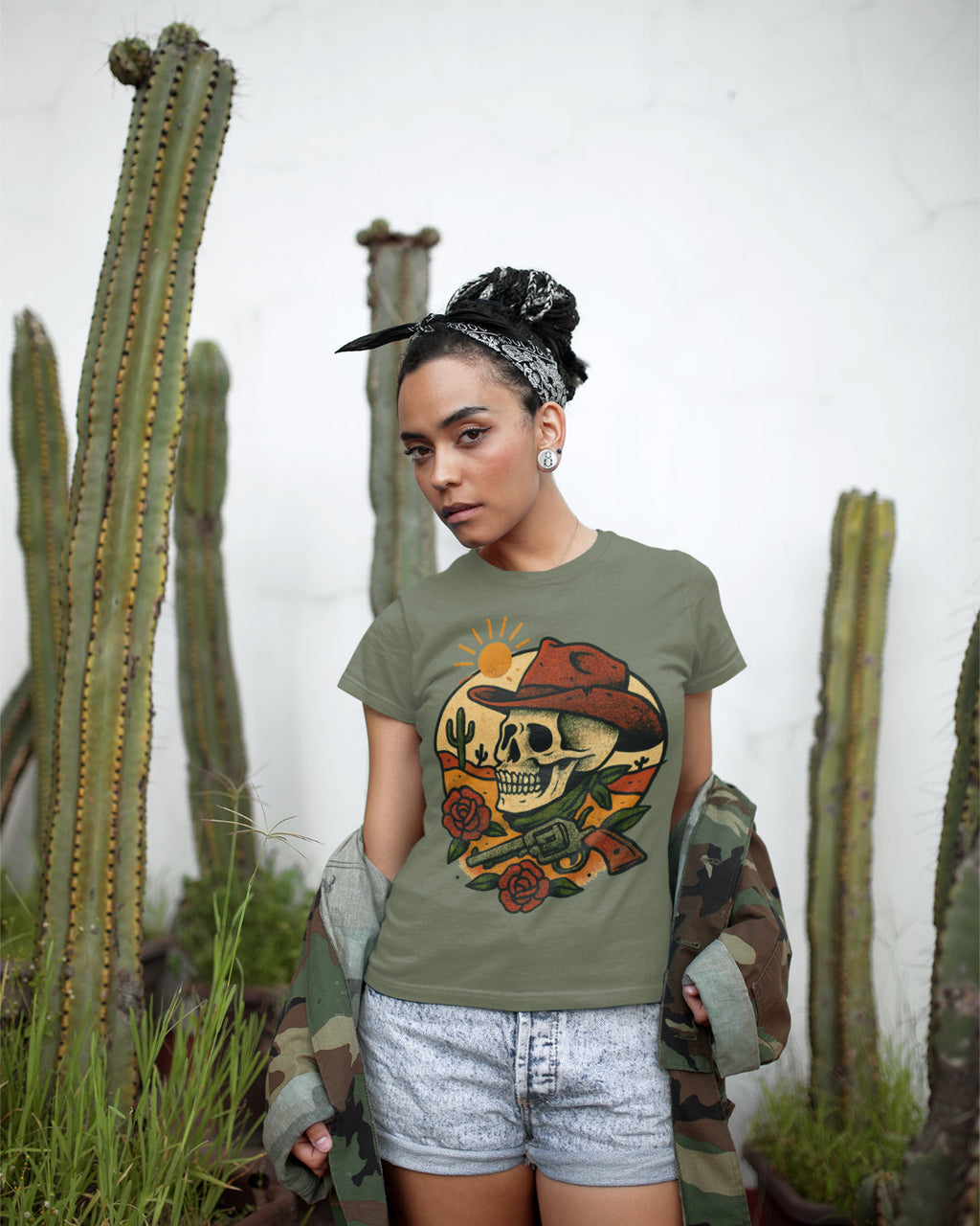 Woman wearing a graphic t-shirt with a skull design in front of cacti