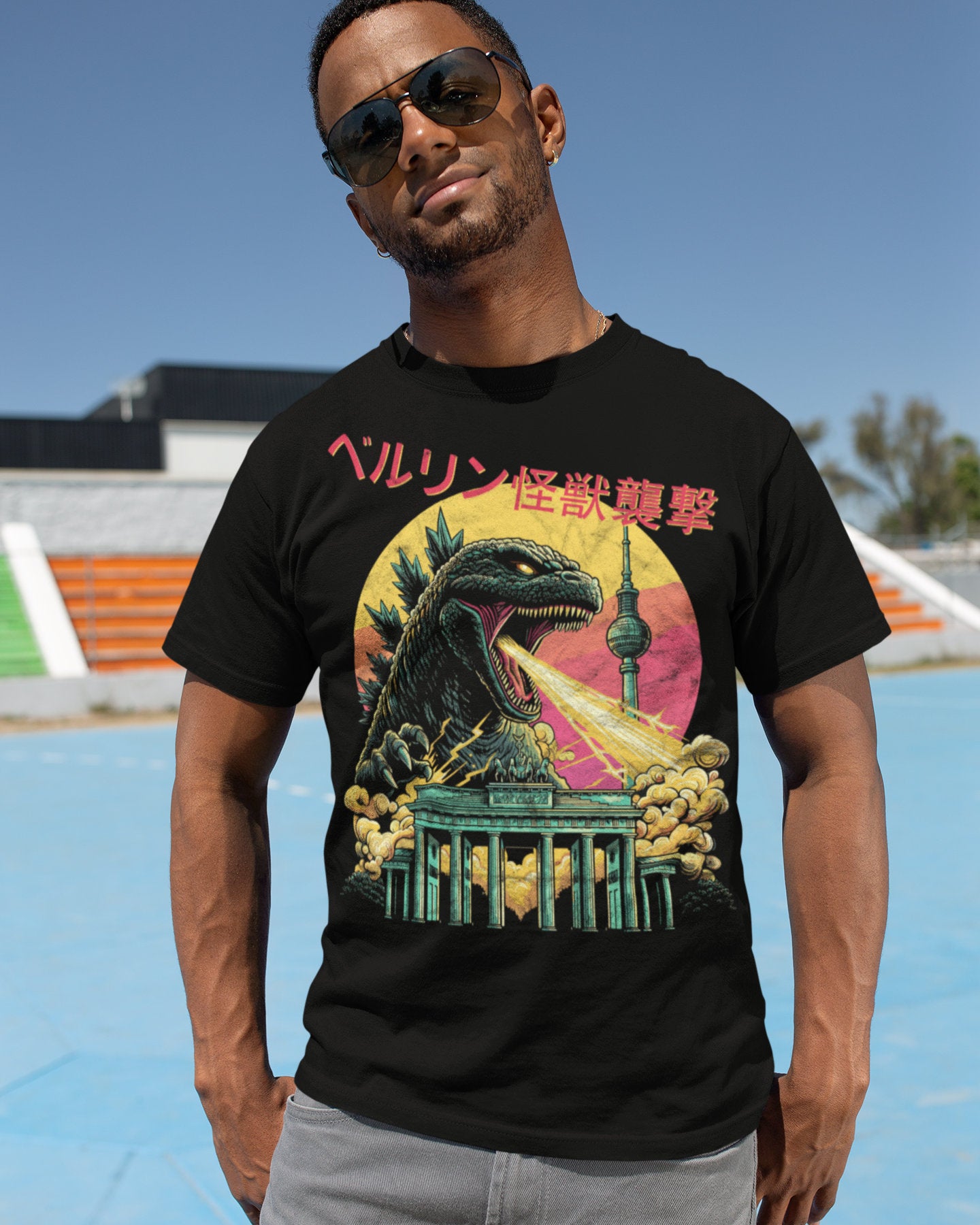 Man wearing a black graphic t-shirt featuring a giant kaiju against the berlin skyline