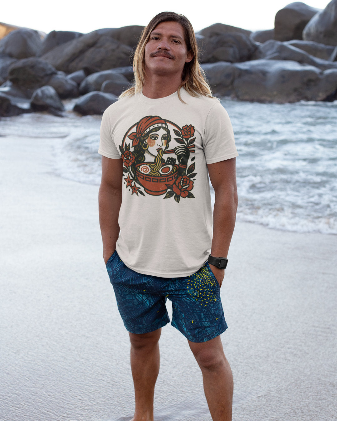 Man standing on a beach wearing a gypsx girl t-shirt and shorts. 