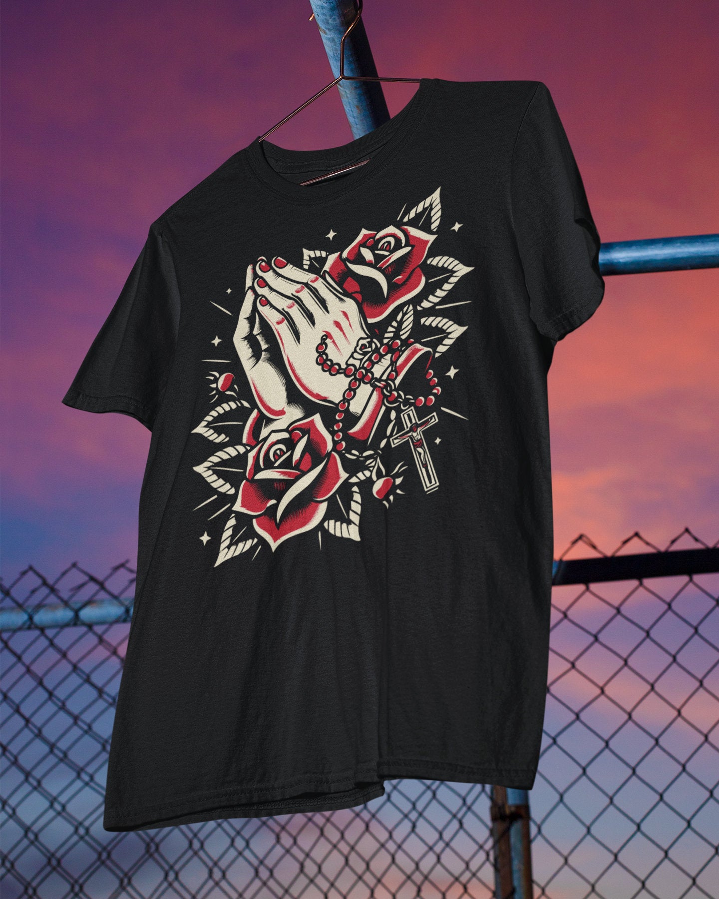 Black t-shirt with a graphic design of praying hands and a rosary