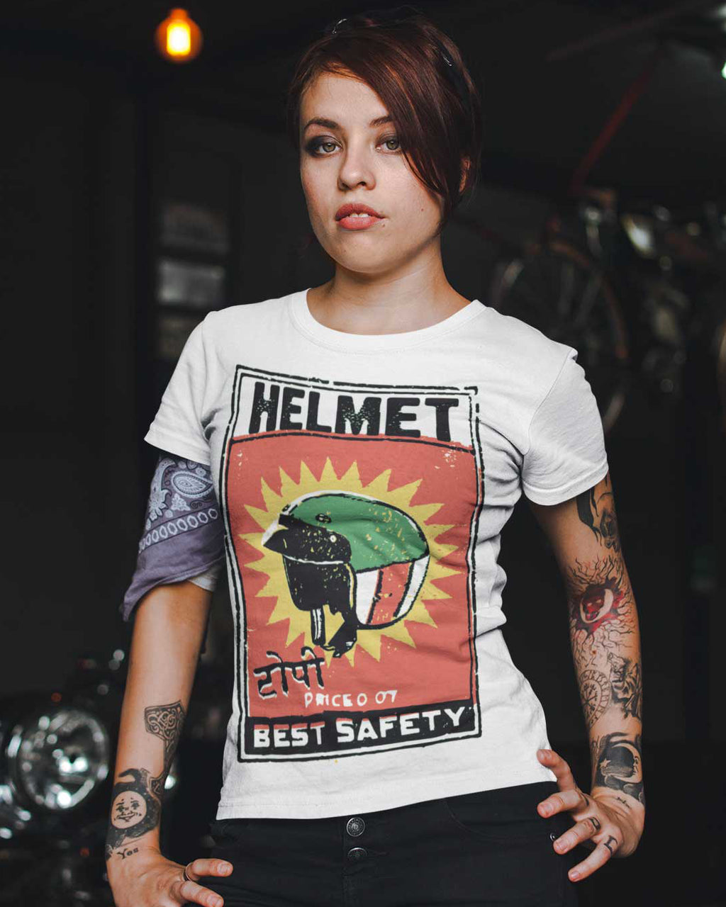 Person wearing a white t-shirt with a graphic design of a helmet and text.