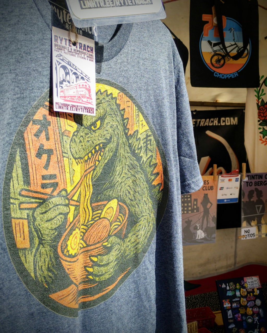 Giant Kaiju Eating Ramen Noodles T-Shirt on market stand