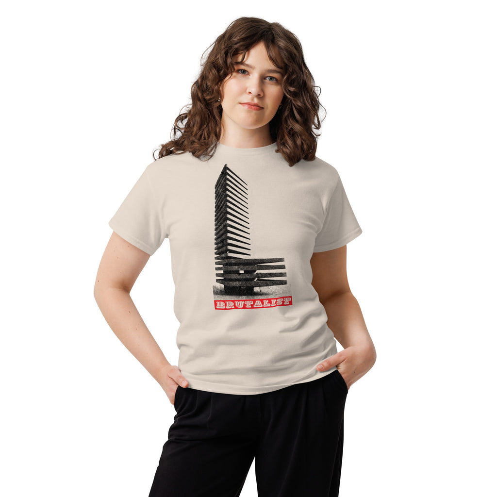 A woman modeling a light beige t-shirt with a black piano keys graphic and the word 'Brutalist' in red text, paired with black pants, against a plain white background.