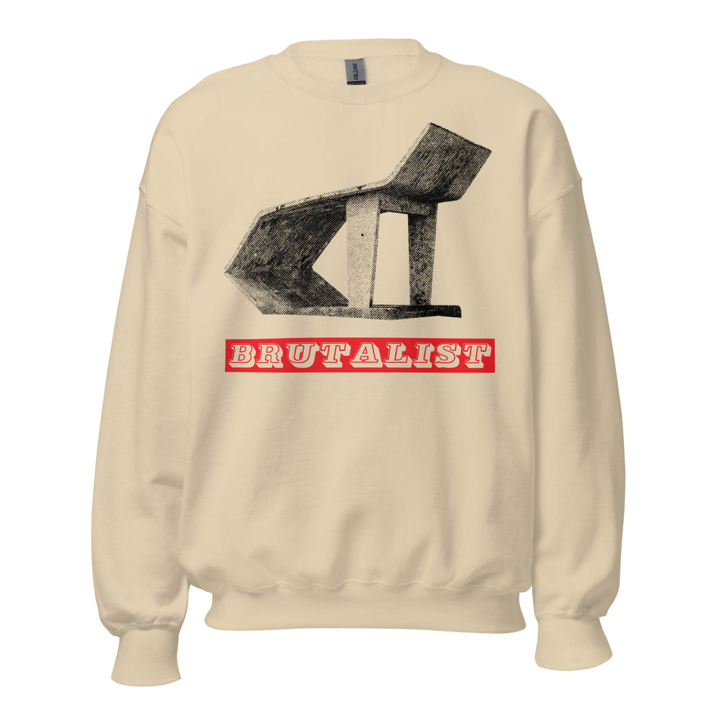 A cream-colored crewneck sweatshirt featuring a black sketch-style graphic of a brutalist chair and a red banner with the word 'BRUTALIST' in white, displayed on a clean white background.